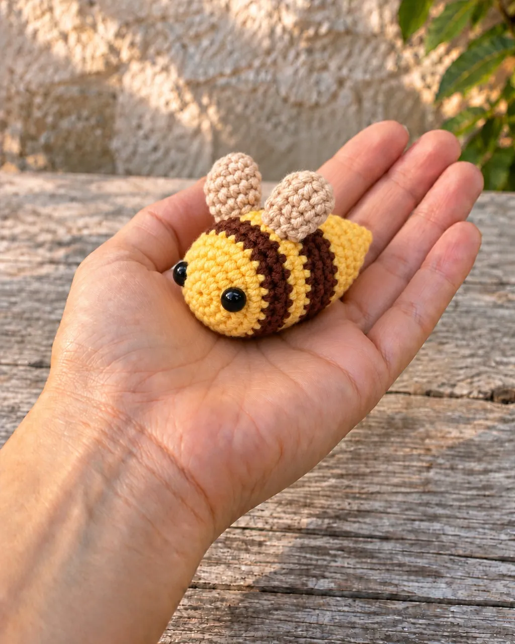 The bee lying on an open palm, an arm extending into the frame from the lower left.